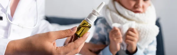 Pediatra con spray nasale vicino a una ragazza malata su sfondo sfocato, banner — Foto stock