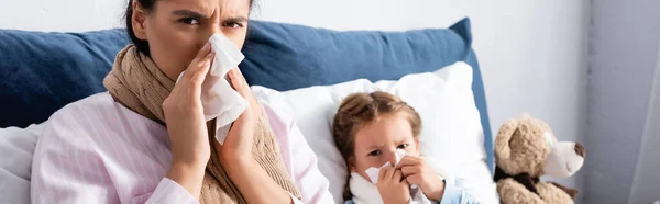 Niño enfermo y madre con secreción nasal estornudos en servilletas de papel, pancarta - foto de stock