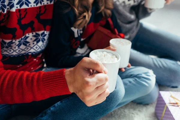 Vue recadrée de l'homme et de la femme tenant du cacao avec des guimauves dans des tasses — Photo de stock