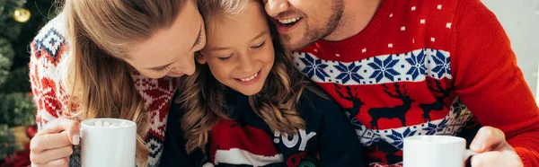Glückliche Familie in Pullovern mit Tassen mit Getränken zu Weihnachten, Banner — Stockfoto