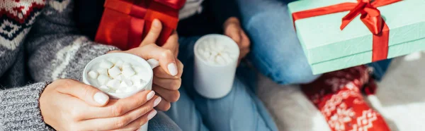 Familie in Pullovern mit Tassen mit Getränken zu Weihnachten, Banner — Stockfoto