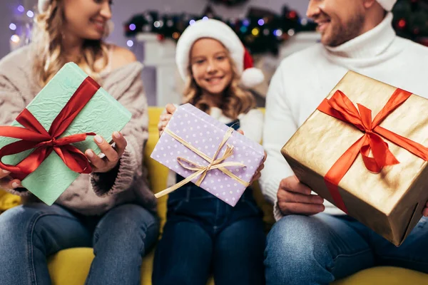 Regali di Natale in mani di famiglia gioiosa su sfondo sfocato — Foto stock