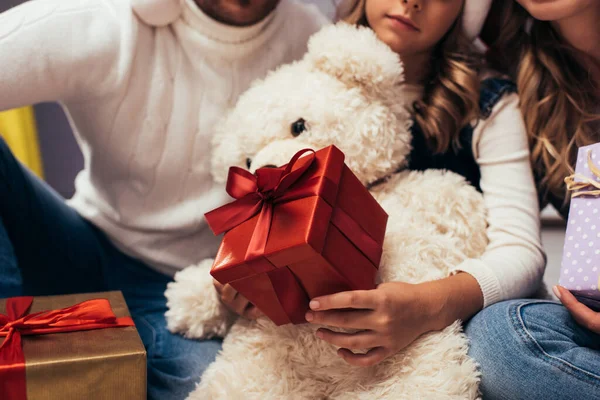 Обрезанный вид ребенка с рождественскими подарками рядом с родителями — стоковое фото