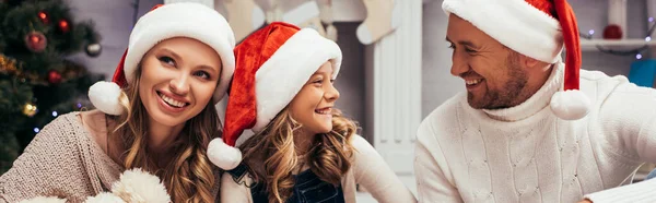 Щаслива сім'я в капелюхах Санти на Різдво, банер — стокове фото