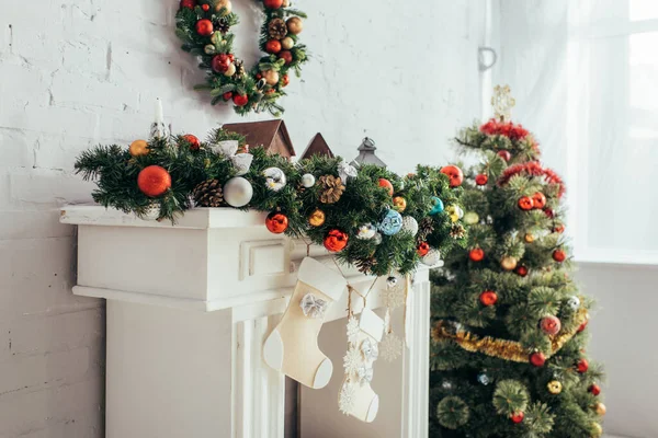 Bas de Noël suspendus près de la cheminée décorée et sapin — Photo de stock