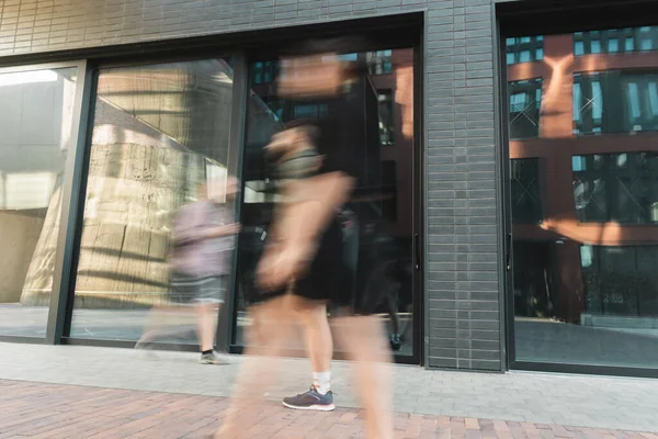 Bürger zu Fuß auf der Straße in der Nähe moderner Gebäude, lange Belichtung — Stockfoto