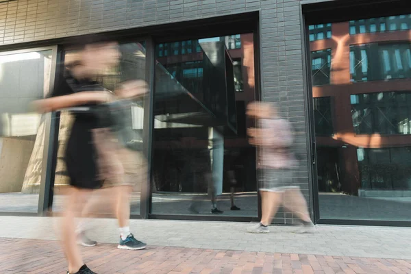 Ciudadanos caminando en la calle cerca del edificio, larga exposición - foto de stock