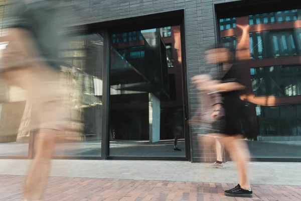 Borrão de movimento de pessoas andando na rua moderna perto do edifício — Fotografia de Stock