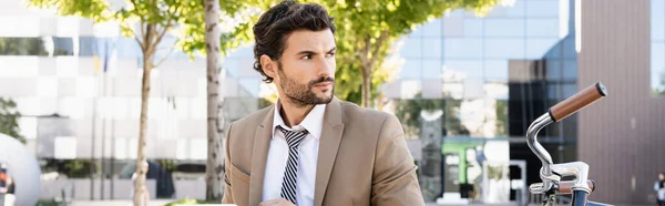 Businessman in suit looking away near bike, banner — Stock Photo