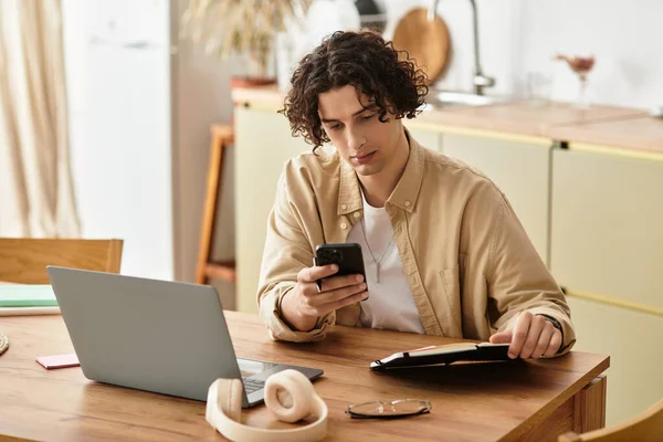 Joven profesional comprueba su teléfono en un escritorio elegante en un espacio de trabajo contemporáneo. - foto de stock