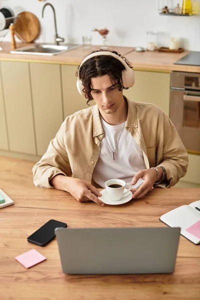 Bonito jovem profissional relaxa com café em um espaço de trabalho bem projetado, focado e engajado. — Fotografia de Stock