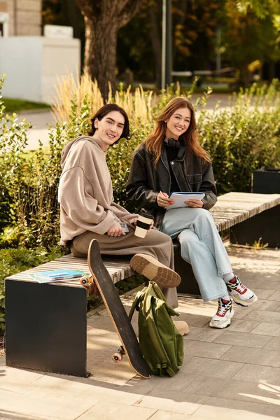 Молода пара насолоджується компанією один одного, сидячи на лавці в оточенні зелені. — стокове фото