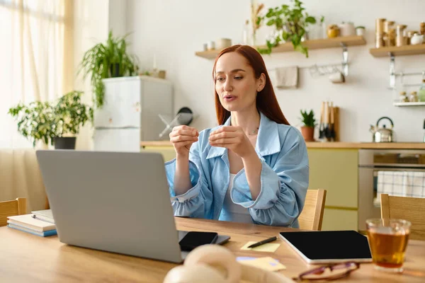 A dedicated language teacher with red hair is teaching online from her cozy home environment. — стоковое фото