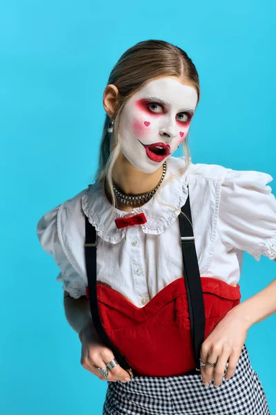 Молодая женщина, одетая в яркий костюм Хэллоуина, уверенно позирует с ярким макияжем. — стоковое фото