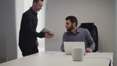sakallı danışmanlık için bir teşvik geliştirici tablet ellerde ile gelir Proje Yöneticisi masada dizüstü bilgisayarda çalışan ve sonra kibarca onun değişiklik yapar