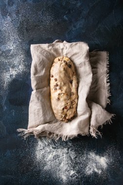 Christmas cake, geleneksel Alman şenlikli pişirme. Kepekli hamur stollen Hazırlama keten koyu mavi doku arka plan peçete üzerinde. Üstten görünüm, uzay