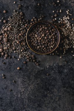 Farklı siyah biber yenibahar, yenibahar, rahipler biber, karabiber eski siyah demir doku arka plan üzerinde teneke kutu içinde çeşididir. Üstten görünüm, kopya alanı.