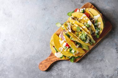 Çeşitli vejetaryen Mısır Tacos sebze, yeşil salata, biber ile krema sosu ile zeytin ahşap tahta üzerinde gri doku arka plan üzerinde servis. Üstten görünüm, kopya alanı.