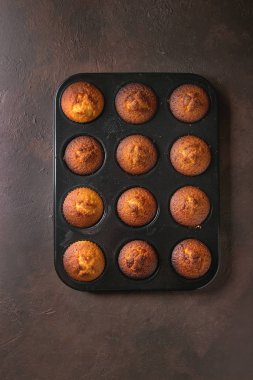 Taze ev yapımı limonlu kek kek siyah teflon pişirme çanağı içinde karanlık doku arka plan üzerinde pişmiş. Üstten görünüm, uzay.