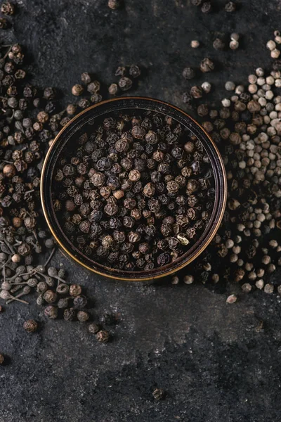 各种不同的黑椒五香粉 花椒在锡罐上能过老黑铁质地的背景 顶部视图 复制空间 — 图库照片