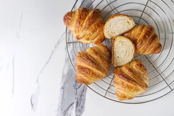 Croissant Caseiro Inteiro Fatiado Rack Refrigeração Sobre Fundo Mármore Branco — Fotografia de Stock