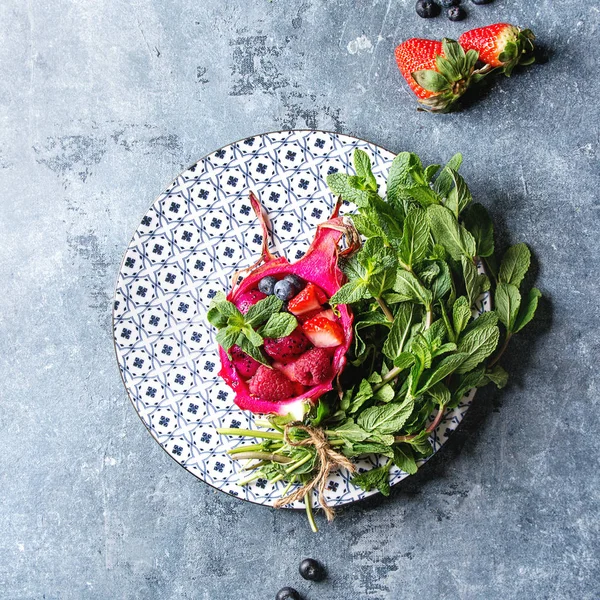 纯素食水果沙拉与浆果和薄荷服务在粉红色的龙果与配料以上的陶瓷板上的蓝色纹理背景 顶部视图 健康饮食 — 图库照片