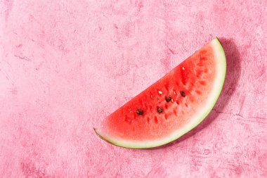 Olgun dilim karpuz pembe doku arka plan üzerinde. Düz lay, uzay.
