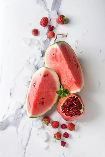 Kırmızı olgun organik meyve çeşitli meyve karpuz, çilek, ahududu, nar kokteyl veya nane ile smoothies ve beyaz mermer arka plan üzerinde buz ezilmiş. Düz yatıyordu