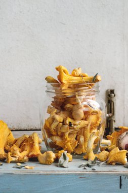 Mavi Beyaz ahşap mutfak masasında cam kavanoza çiğ çiğ Chanterelles orman mantar. Rustik tarzı, gün ışığı, kopya alanı