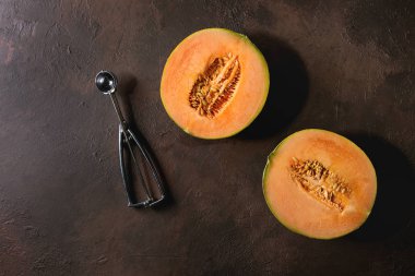 Olgun organik kavun karpuz tohumu ve koyu kahverengi doku arka plan üzerine kaşık yarısı. Düz lay, uzay