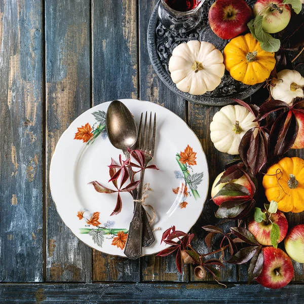 Sonbahar tatil sofra dekorasyon dekoratif kabak, elma, kırmızı yaprakları, ahşap masa üzerinde vintage çatal bıçak takımı ile boş levha. Rustik tarzı, düz yatıyordu. Kare görüntü