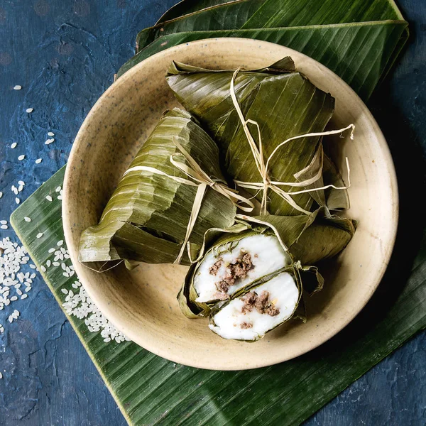 Muz yaprakları dolum etli pirinç tapyoka un dan Köfte Buğulama Asya pirinç piramidal mavi doku arka plan üzerinde pirinç seramik kase görev yaptı. Üstten görünüm alanı. Kare görüntü