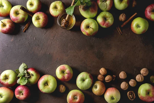 Olgun organik bahçe yeşil kırmızı elma yaprağı, ceviz, tarçın ve kavanoz bal karanlık doku arka plan üzerinde. Yat, alanı Kopyala. Sonbaharda hasat gıda arka plan