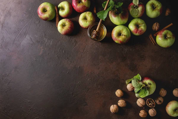 Olgun organik bahçe yeşil kırmızı elma yaprağı, ceviz, tarçın ve kavanoz bal karanlık doku arka plan üzerinde. Yat, alanı Kopyala. Sonbaharda hasat gıda arka plan