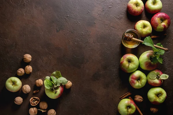 Olgun organik bahçe yeşil kırmızı elma yaprağı, ceviz, tarçın ve kavanoz bal karanlık doku arka plan üzerinde. Yat, alanı Kopyala. Sonbaharda hasat gıda arka plan