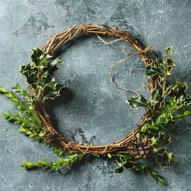 Yeşil dallar ve koniler mavi doku arka plan üzerinde basit el yapımı Noel çelenk. Görünümü en çok, uzay kopyalayın. Noel tebrik kartı. Kare görüntü