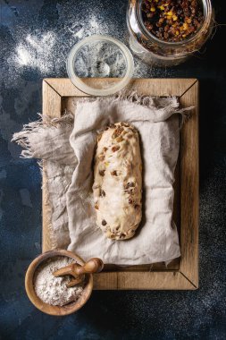 Christmas cake, geleneksel Alman şenlikli pişirme. Kepekli hamur stollen hazırlık ile keten peçete üzerine un ve kuru üzüm koyu mavi doku arka plan üzerinde kase. Üstten görünüm, uzay