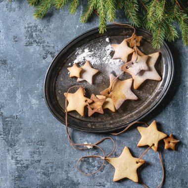 Ev yapımı kurabiye yıldız şekli şeker kurabiye farklı boyutu iplik içinde çam dalları ile vintage metal tepsi üzerinde mavi doku yüzey üzerinde. Noel arka plan. Üstten görünüm alanı. Kare görüntü