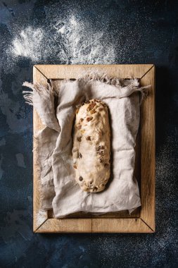 Christmas cake, geleneksel Alman şenlikli pişirme. Kepekli hamur stollen Hazırlama keten koyu mavi doku arka plan peçete üzerinde. Üstten görünüm, uzay