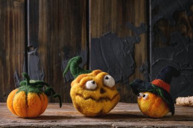 Komik zanaat Cadılar Bayramı iğne çeşitli pumpkins jack o fener tatil dekor sonbahar sarı yaprakları ve meyveleri ile eski ahşap doku arka plan üzerinde keçeli.