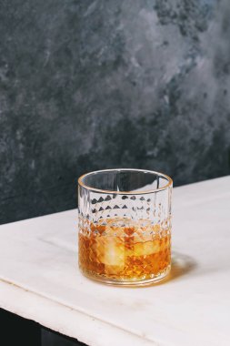 Scotch viski arka plan, gri duvar beyaz mermer masada duran buz cam. Alkol içki.