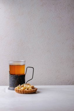 Ev yapımı tatlı elma kurabiye tartı beyaz tabak, bardak sıcak çay vintage Kupası tutucu beyaz mermer tablo içinde. Pişirme sonbahar. Minimalist tarzı.
