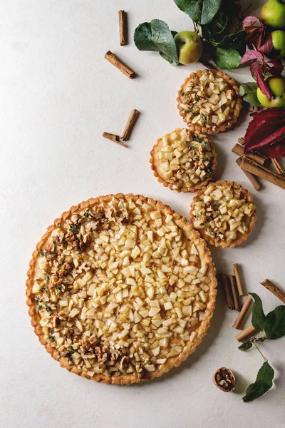 自制的甜苹果酥挞和 Tartlets 与肉桂棒 苹果树枝以上的白色大理石背景 秋季烘焙 — 图库照片