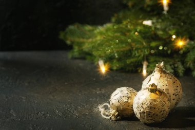 Craft kağıt Noel topları vintage müzik notlar köknar ağacı ve karanlık doku arka plan üzerinde yanan garland ile kümesi. Noel tatil ruh kartı.