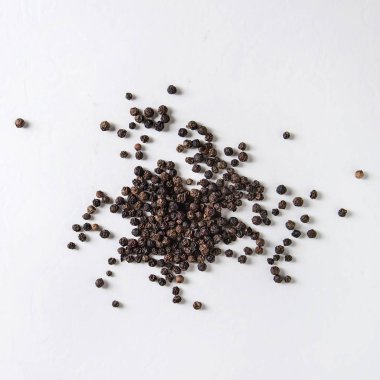 Beyaz arka plan üzerinde siyah biber peppercorns yığını. Üstten görünüm alanı. Kare görüntü