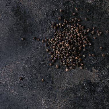 Eski siyah demir doku arka plan üzerinde siyah biber peppercorns yığını. Görünümü en çok, uzay kopyalayın. Kare görüntü