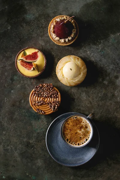 各种甜馅饼与巧克力 无花果与杯咖啡在黑色纹理背景 — 图库照片