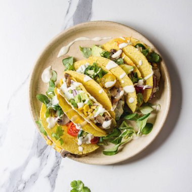 Çeşitli vejetaryen Mısır Tacos sebze, yeşil salata, biber ile krema sosu ile seramik plaka üzerinde beyaz mermer arka plan üzerinde servis. Görünümü en çok, uzay kopyalayın. Kare görüntü