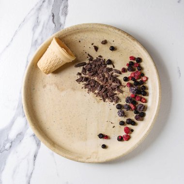 Dondurma için dekor malzemeler. Küçük gözleme Kupası, dondurulmuş çilek, koyu çikolata üzerinde beyaz mermer zemin seramik tabak içinde kıyılmış. Üstten görünüm alanı. Kare görüntü