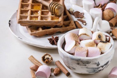 Sıcak çikolata hatmi s'mores ev yapımı tatlım gofret ve beyaz mermer masa üzerinde yukarıda malzemeler ile seramik bardak. Kış içki. Yakın çekim